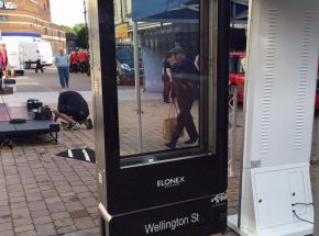 A digital advertising totem being erected in a town centre